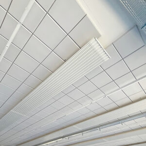Weisse Akustikplatten als flächige Kassettendecke mit Lichtleisten in Industriehalle von unten fotografiert